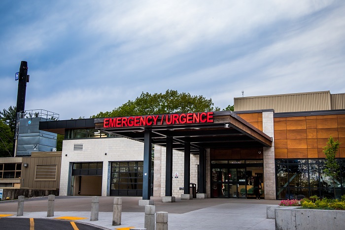 White double doors for ambulance entry and roof with red Emergency sign.