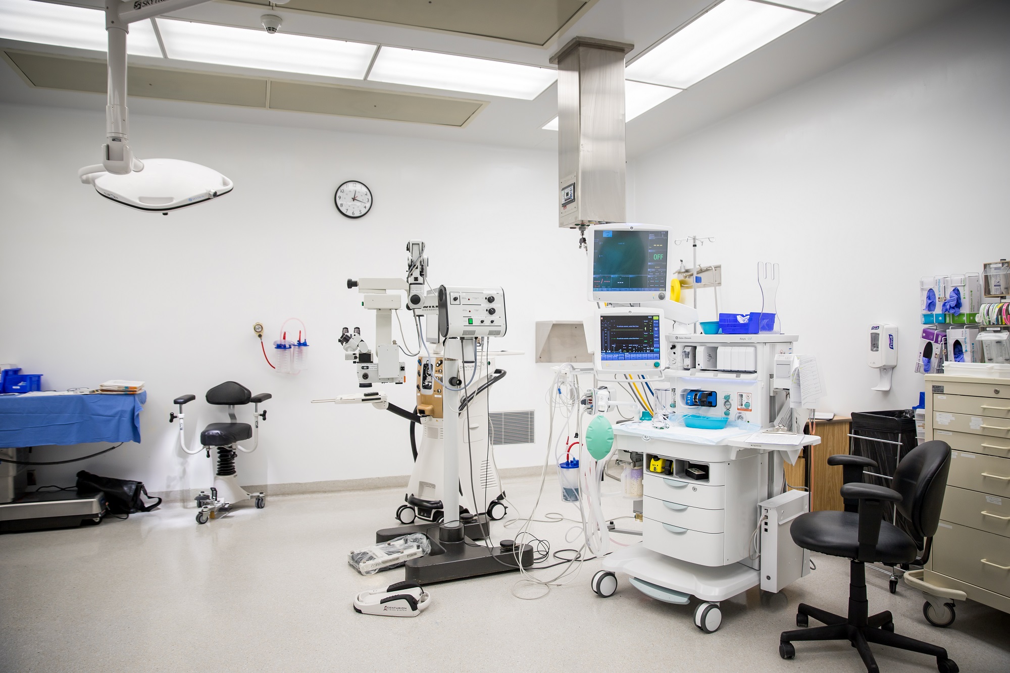 Empty operating room showing many pieces of equipment.