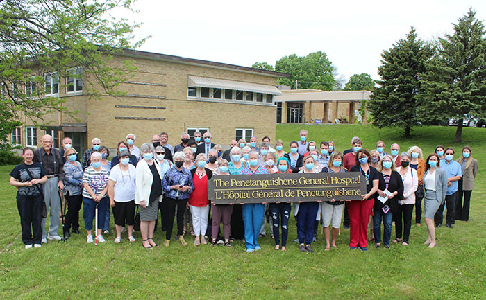 A very large group of health workers outside holding a sign that says The Penetanguishene General Hospital