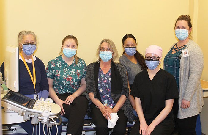 Six members of the GBGH staff posing with an ultrasound machine.