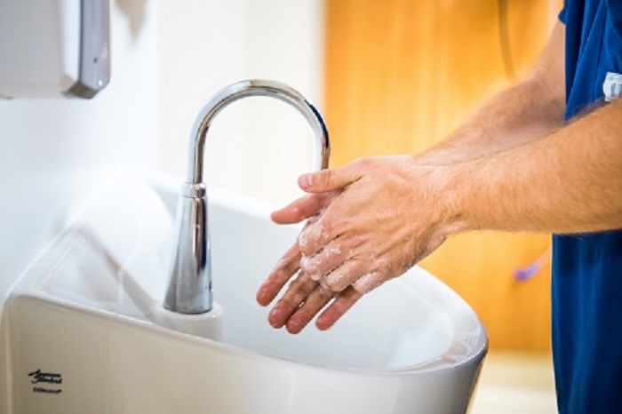 A sink with a man washing his hands